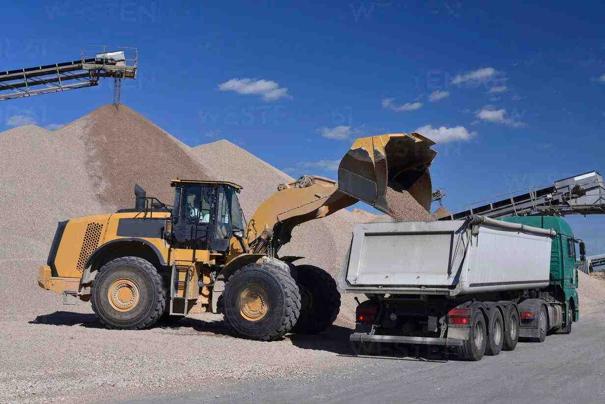 Imagen descriptiva de Maquina excavadora cargando camion con arena